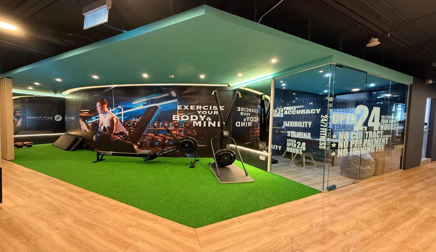 247 Fitness gym training floor fit-out by Trident Fitout, artificial turf area beneath a brand mural wall