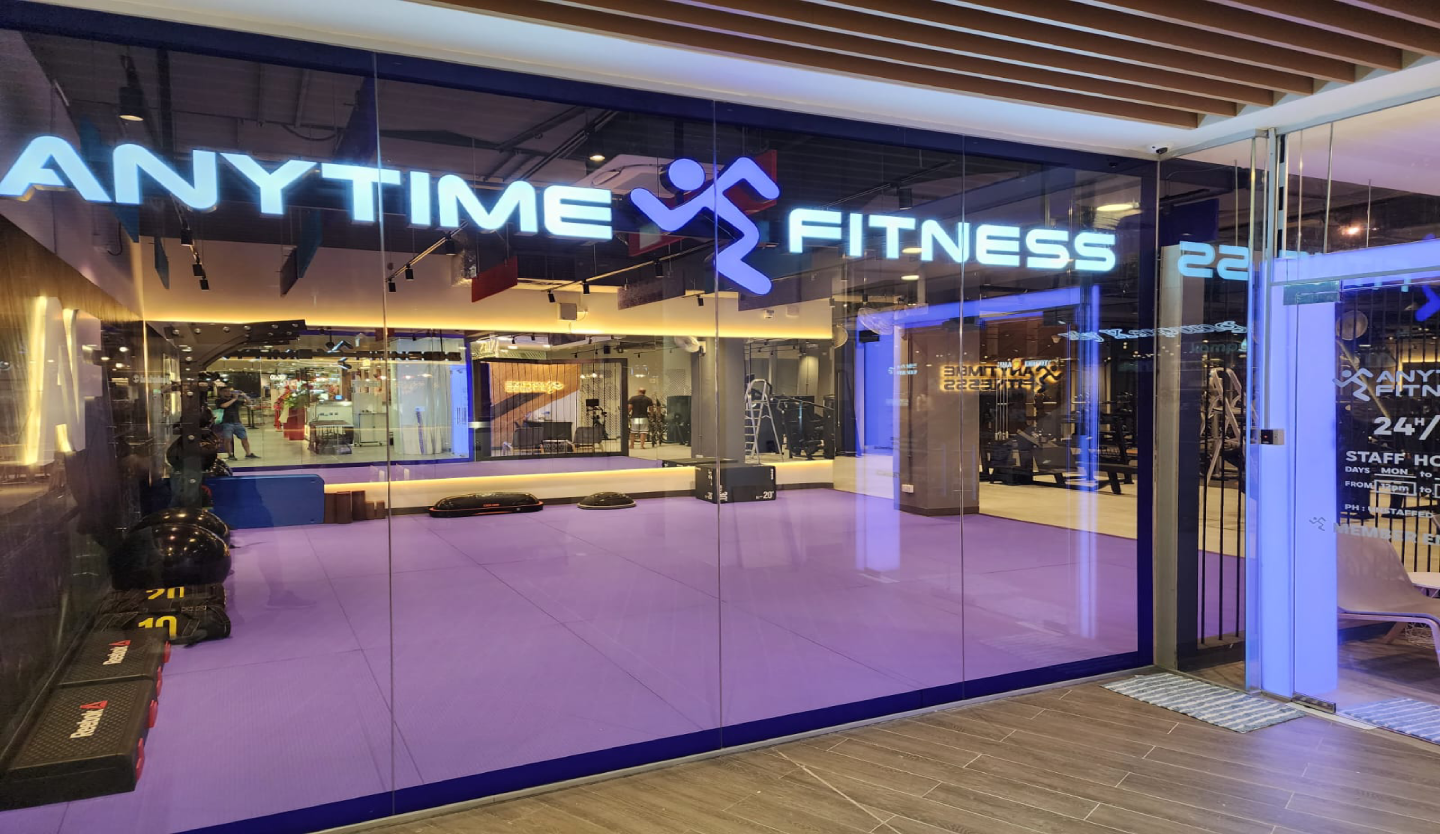 Anytime Fitness gym storefront fit-out by Trident Fitout, glass corner unit with violet accent lighting on the training floor
