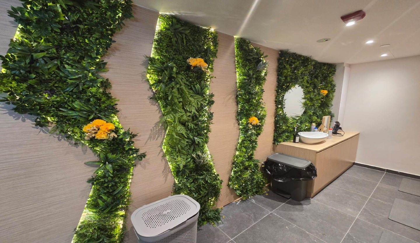 Body Fit Training washroom fit-out by Trident Fitout, vanity counter beneath plant wall panelling with flower accents