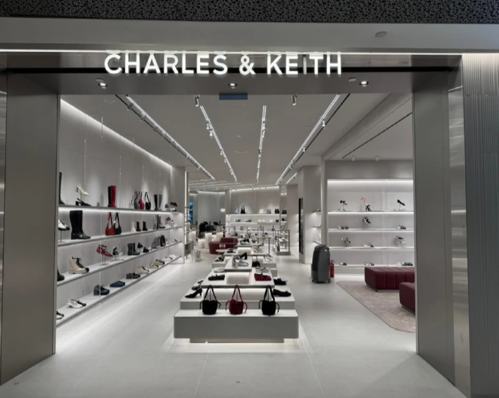 Charles & Keith retail store entrance fit-out by Trident Fitout, backlit signage above the doorway with shoe and bag displays on either side