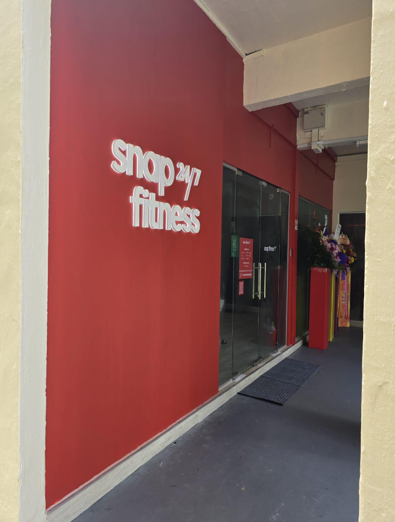 Snap Fitness gym entrance fit-out by Trident Fitout, glass doors beneath red feature wall signage
