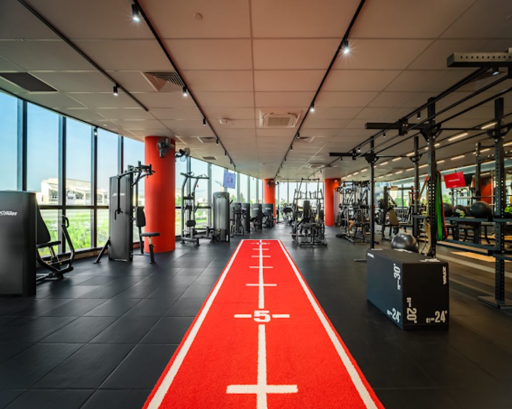 Snap Fitness gym training floor fit-out by Trident Fitout, red running lane between strength equipment beneath floor-to-ceiling windows